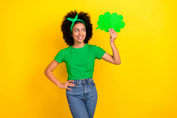 Photo of thoughtful pretty girl dressed green t-shirt hairband rising mind cloud empty space isolated yellow color background