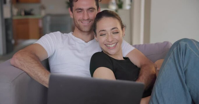 Couple, laptop and laugh on sofa in home to watch movies, streaming multimedia and comedy show online. Happy man, woman and relax in living room at computer, funny video or entertainment subscription