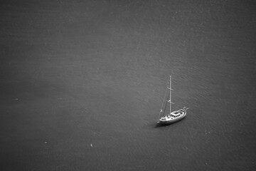 Small sailboat on the lake. Black and white photo. View from above.