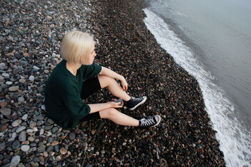 Young female model relaxing on sea coast outdoors