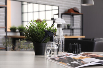 Hairdressing tools and magazine on table in beauty salon
