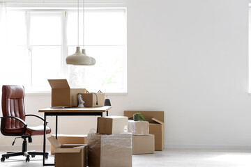 Interior of stylish office with cardboard boxes on moving day - obrazy, fototapety, plakaty