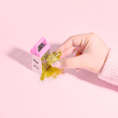 Creative Christmas composition. Woman's hand grate Christmas ball on pink table background. Flat...