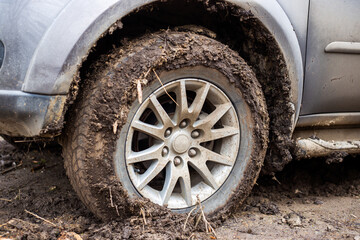 Car tire covered with mud. Driving in the rainy season off-road, bad roads and traffic