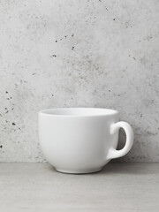 One white ceramic cup on the table