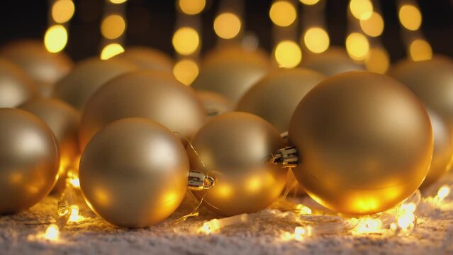 Golden Christmas tree decorations for Christmas and New Year. The light glitter in bokeh mode turns your video's background into a magical light skate for holiday looks and decorations.