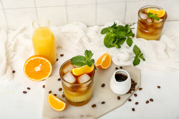 Glasses of tasty orange espresso and ingredients on table