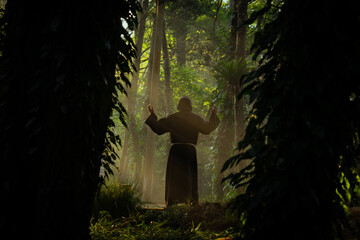 Monje fraile franciscano religioso católico, cristiano meditando o rezando y contemplando la...