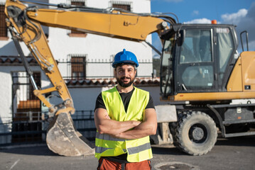 construction worker near to backhoe looking at camera smiling