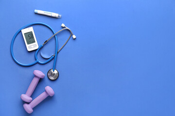 Glucometer, dumbbells, lancet and stethoscope on blue background. Diabetes concept