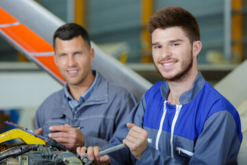 two flight engineers working in aircraft hangar