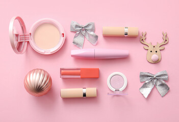 Composition with decorative cosmetics and Christmas decor on pink background