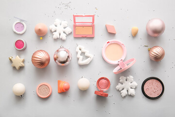 Composition with makeup products and Christmas decor on grey background