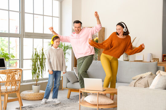 Happy family dancing in living room at home