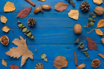 Autumn leaves with decor on wooden background, top view