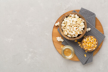 Obraz na płótnie Canvas Prepared popcorn with ingredients on concrete background, top view