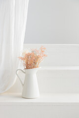Dry flowers in white vase on whitehouse porch. Minimalist still life