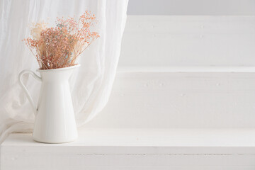 Dry flowers in white vase on whitehouse porch. Minimalist still life