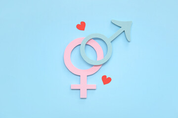 Female and male gender symbols and hearts on blue background