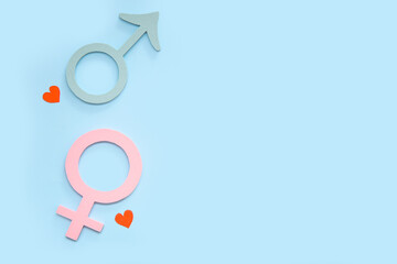 Female and male gender symbols and hearts on blue background