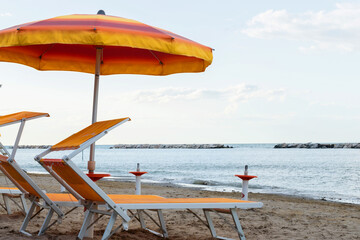 Parasol umbrella on tropical island beach. Colourful sunshade in the beach on sunny summer day. Holiday relaxation with turquoise sea and blue sky landscape. Summer vacation travel concept