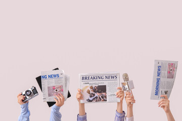 Female hands with different newspapers, microphone and photo camera on light background