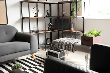 Interior of modern living room with soft bench, sofa and shelving unit