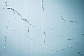 Blue wall with some cracks for humidity as background 