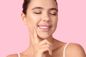 Young woman with beautiful lips on pink background, closeup