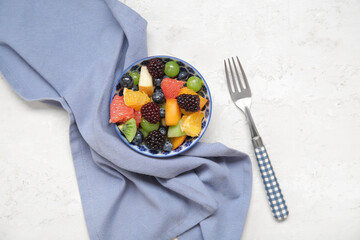 Bowl of fresh fruit salad on light background