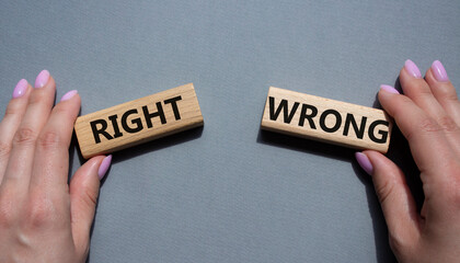 Right or Wrong symbol. Concept word Right or Wrong on wooden blocks. Businessman hand. Beautiful grey background. Business and Right or Wrong concept. Copy space