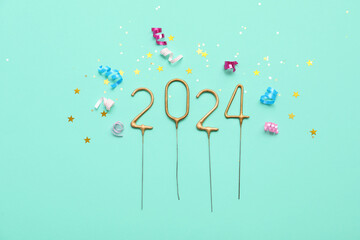 Figure 2024 made of sparklers with Christmas confetti on turquoise background