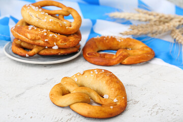 Plate with soft pretzels and flag of Bavaria on white background
