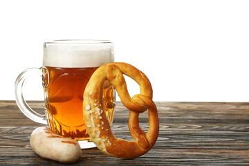 Mug of cold beer, sausage and pretzel on table against white background. Oktoberfest celebration