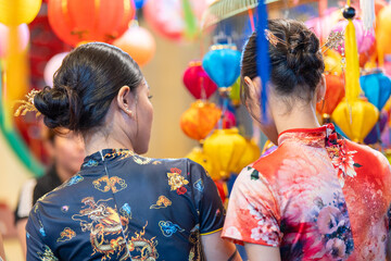 People in front of traditional colorful lanterns hanging on a stand in the streets of Cholon in Ho...