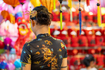 People in front of traditional colorful lanterns hanging on a stand in the streets of Cholon in Ho...