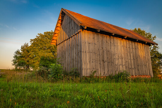 Old wooden barn with sunset colors and blue sky in Krkonose mountains