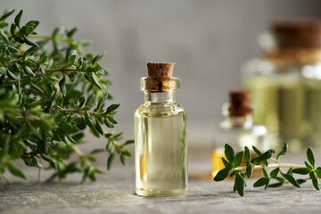 A bottle of thyme essential oil with fresh thyme - obrazy, fototapety, plakaty