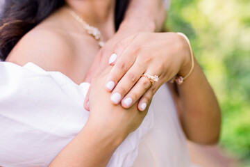 Hands and arms are wrapped around lover, husband, or fiance.