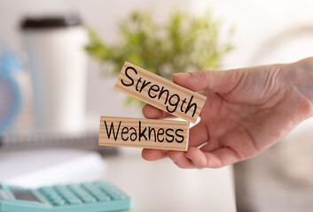 Strength Weakness word written on wood block. helpful tips text on table, concept