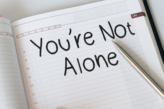 You're Not Alone text on notepad, concept background