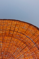 Photo of a round straw knit umbrella usually found on beaches.