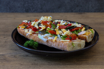 木材背景の黒い皿にのせたオープンサンド