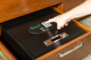 Hand opening safe in hotel room to store valuables