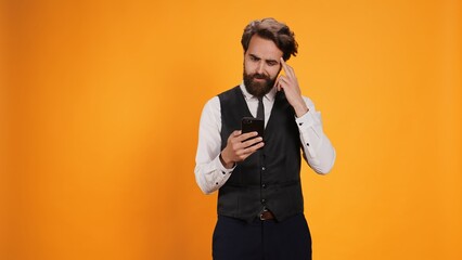 Before serving guests at table, classy butler checks phone looking at online web page against...