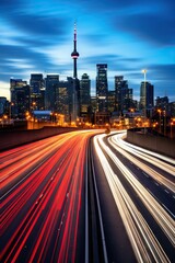Fototapeta premium A photograph capturing the motion blur of a busy urban highway during the evening rush hour. The city skyline serves as the background, illuminated by a sea of headlights and taillights