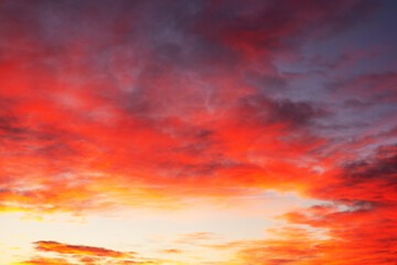 Textured background of beautiful sunset. Amazing red and yellow sunset with "burning clouds" Panoramic sunset cloudscape dramatic sky. Sunset with light reflecting in clouds .