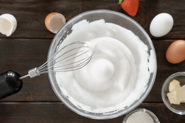 Close-up of a whisk and whipped egg whites to stiff peaks, a step in the preparation of breakfast...