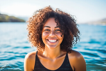 Portrait of beautiful young african american woman smiling and having fun while swimming in ocean