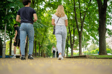 Obraz premium School couple going home together after classes, walking on a pavement